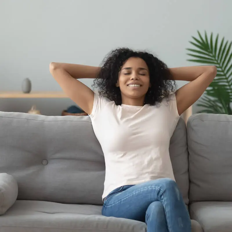 Femme assise divan profite de la température idéale de sa maison